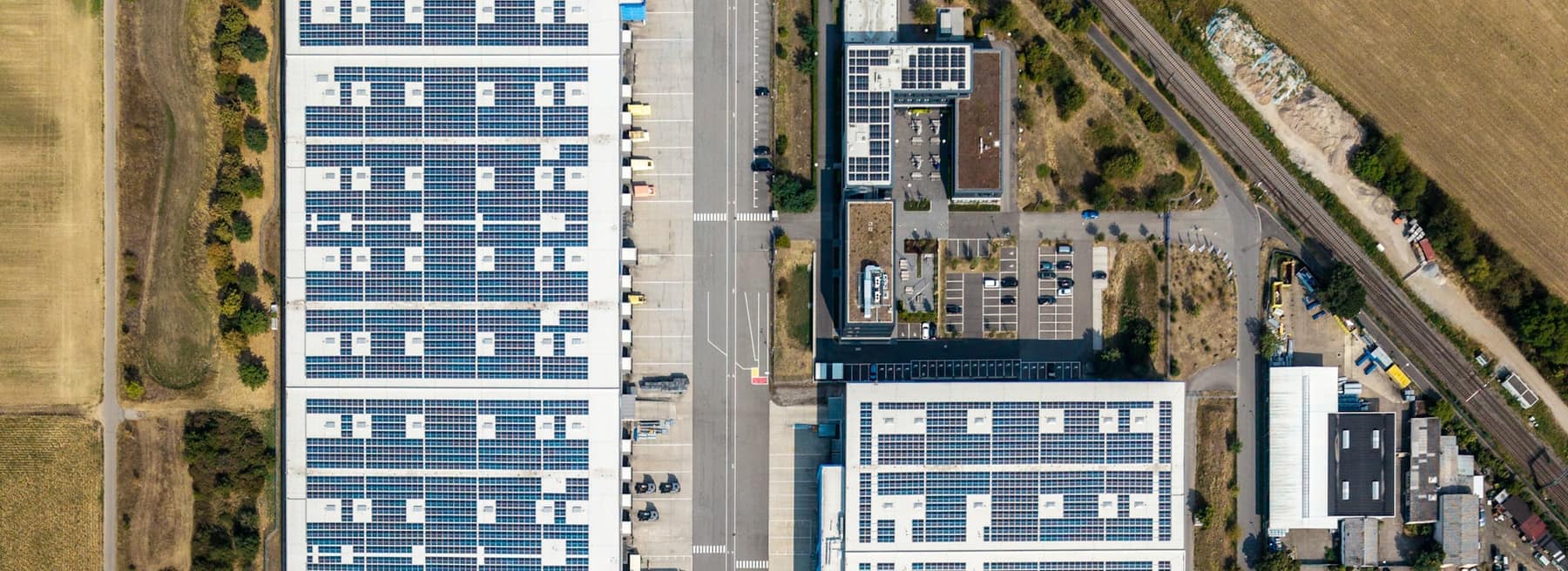 Luchtfoto van bedrijfspanden met zonnepanelen op het dak
